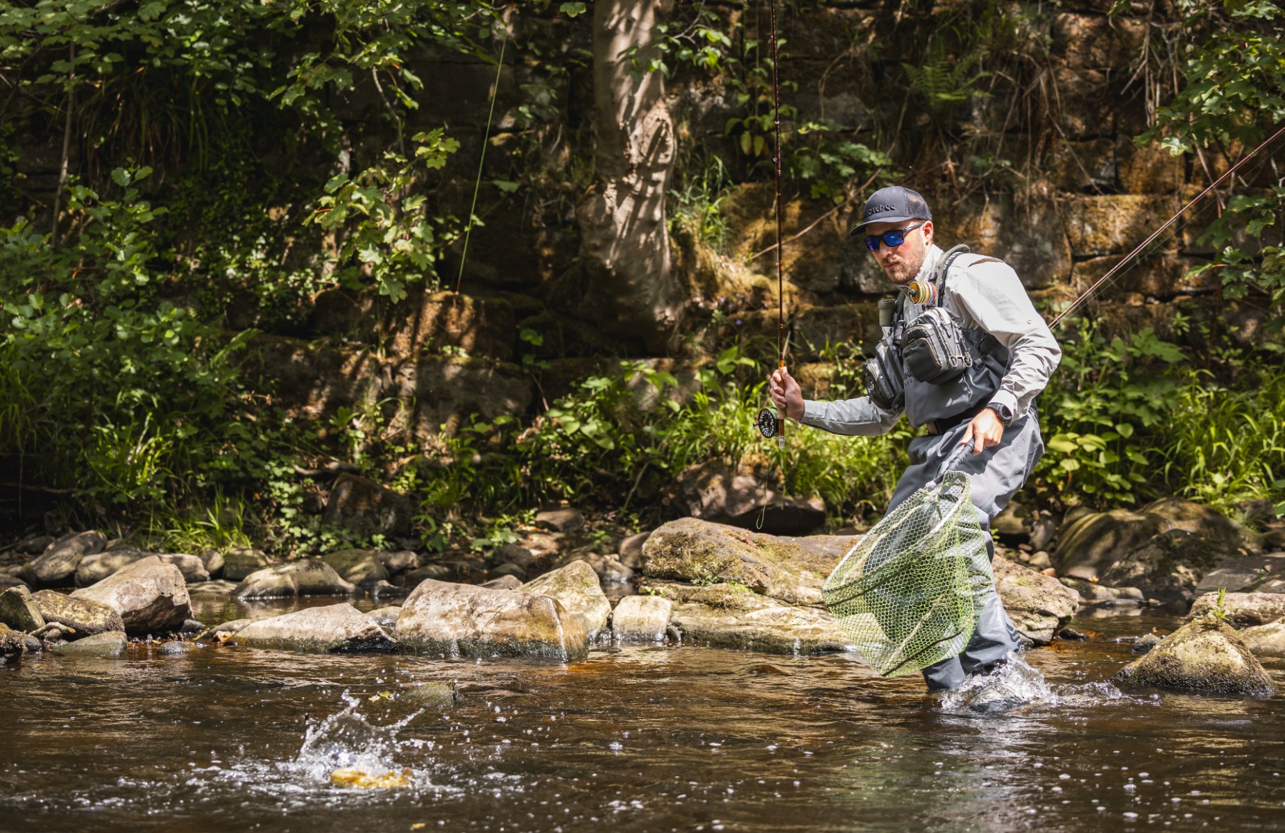 James wades into the water in ready to net a trout