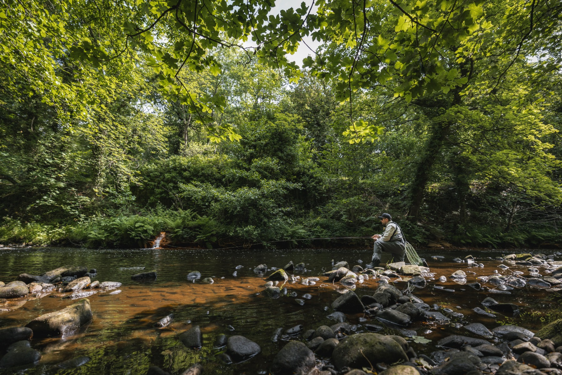 Casting from the rocky shallows into the shaded areas where the trout will hide